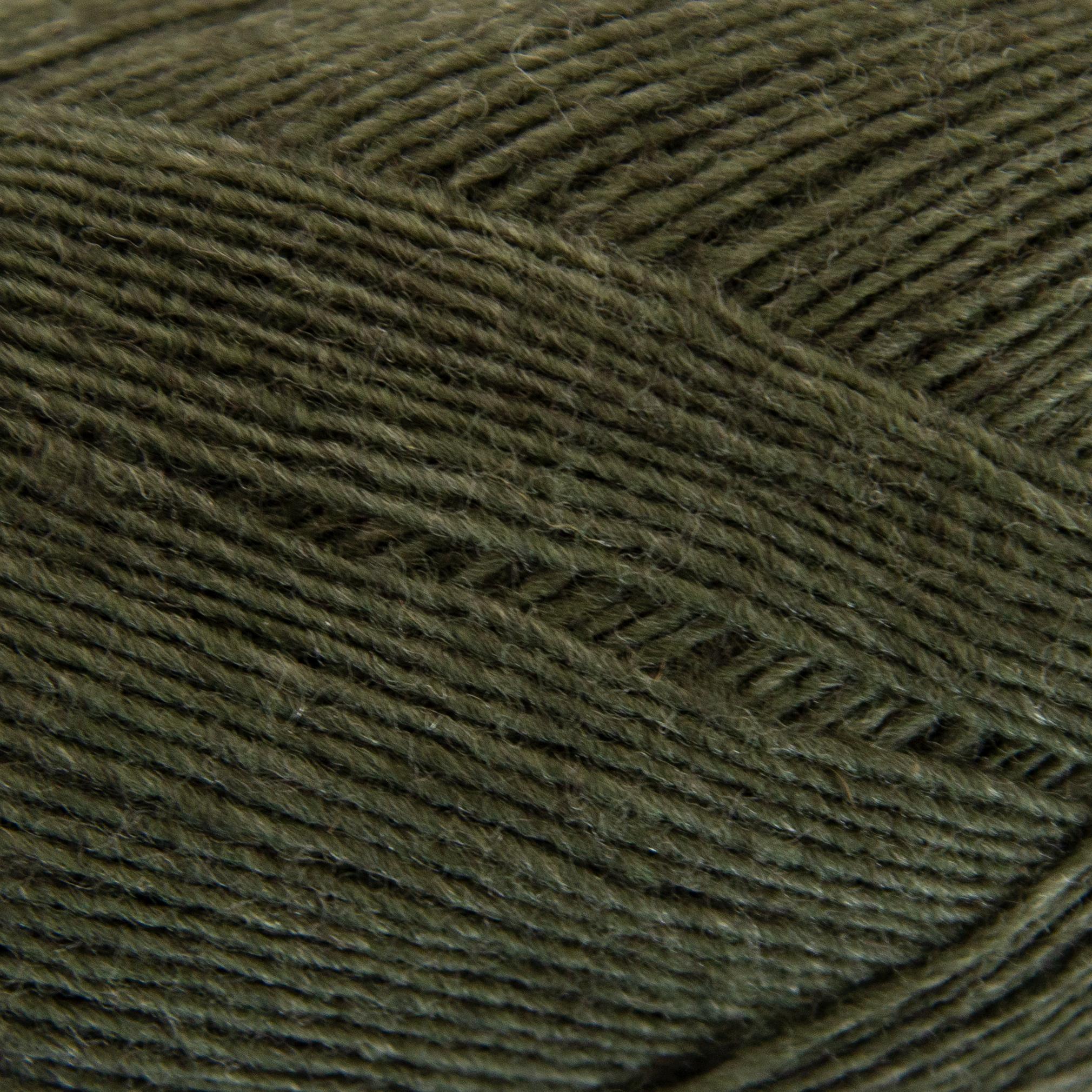 Close-up of a ball of dark green yarn with a textured pattern