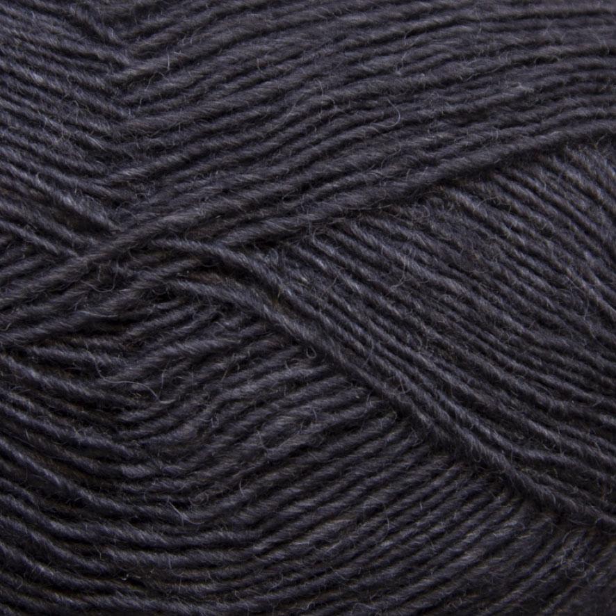 Close-up of a ball of dark charcoal yarn with a textured pattern