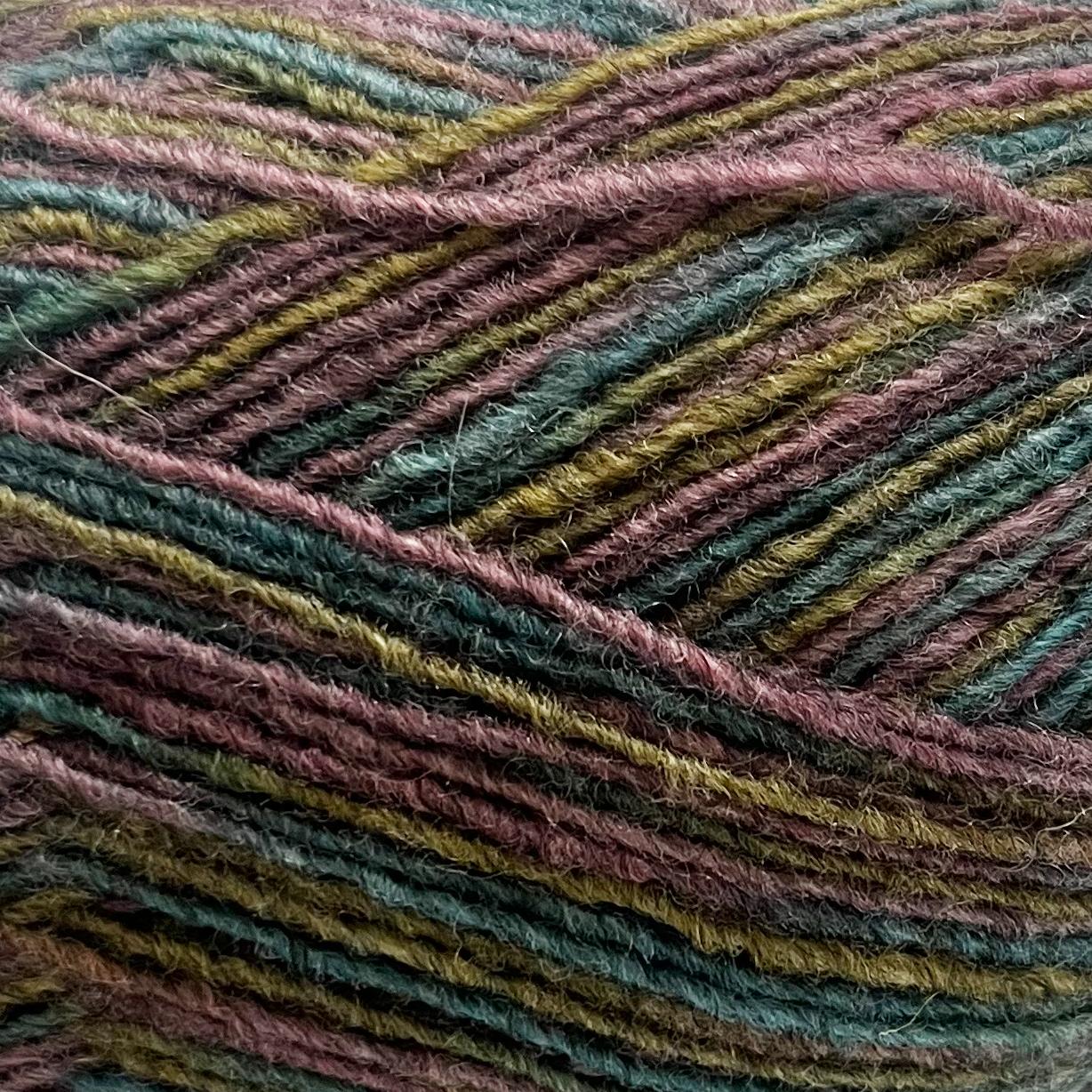 Close-up of a skein of multicolored yarn with earthy tones and a textured pattern