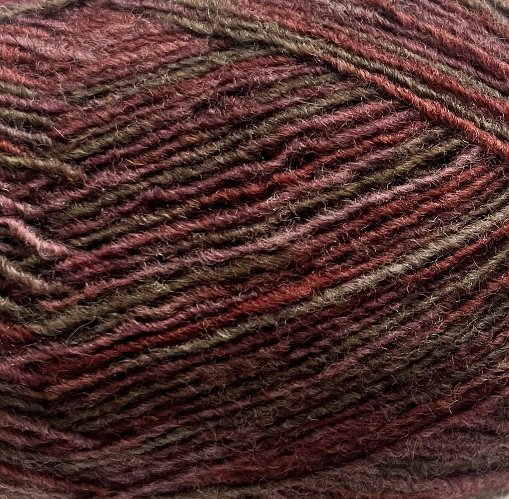 Close-up of a ball of yarn with brown and burgundy tones and a textured pattern