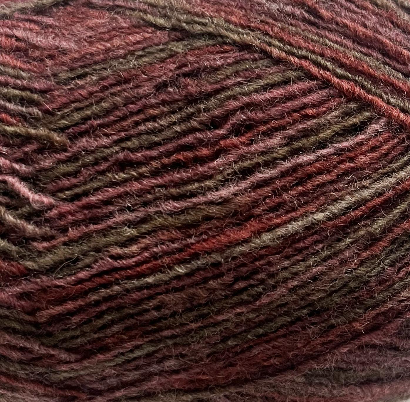 Close-up of a ball of yarn with brown and burgundy tones and a textured pattern