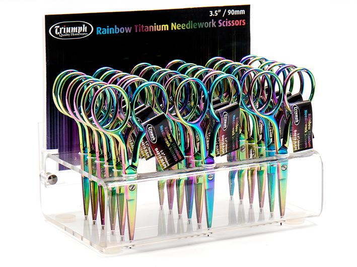 Display of Triumph Rainbow Titanium Needlework Scissors with packaging in the background.