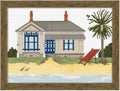 Cross-stitched design of a beach house with a palm tree and lounge chair, framed in wood.