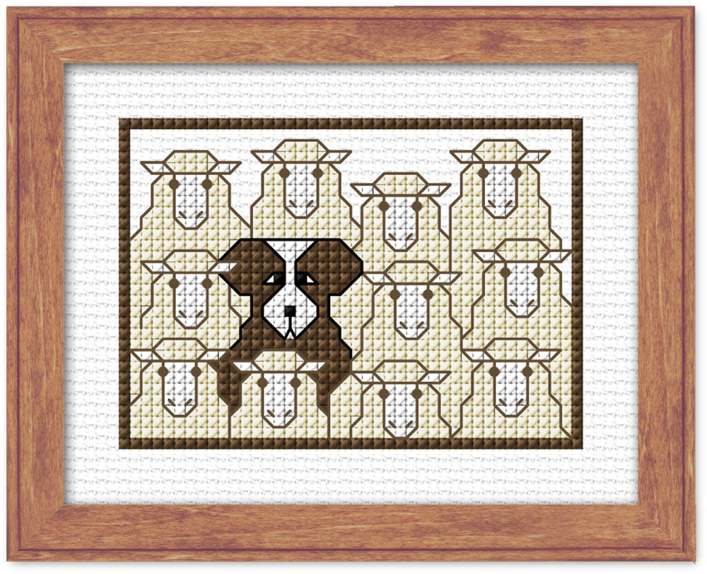 Cross-stitched pattern of a dog's face surrounded by sheep on white fabric with a wooden frame.