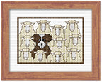 Cross-stitched pattern of a dog's face surrounded by sheep on white fabric with a wooden frame.
