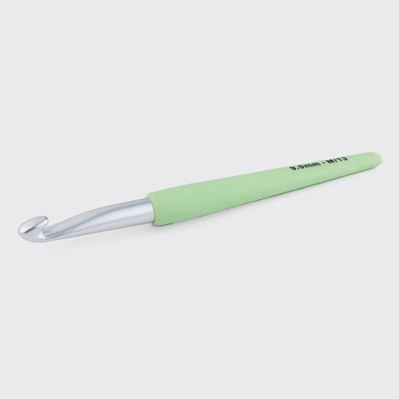 Green crochet hook on a white background