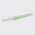 Green crochet hook on a white background