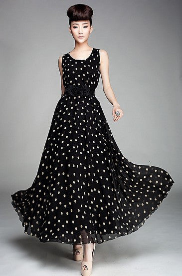 A model wearing a black and white dotted chiffon dress with a sweetheart neckline and a belted waist.