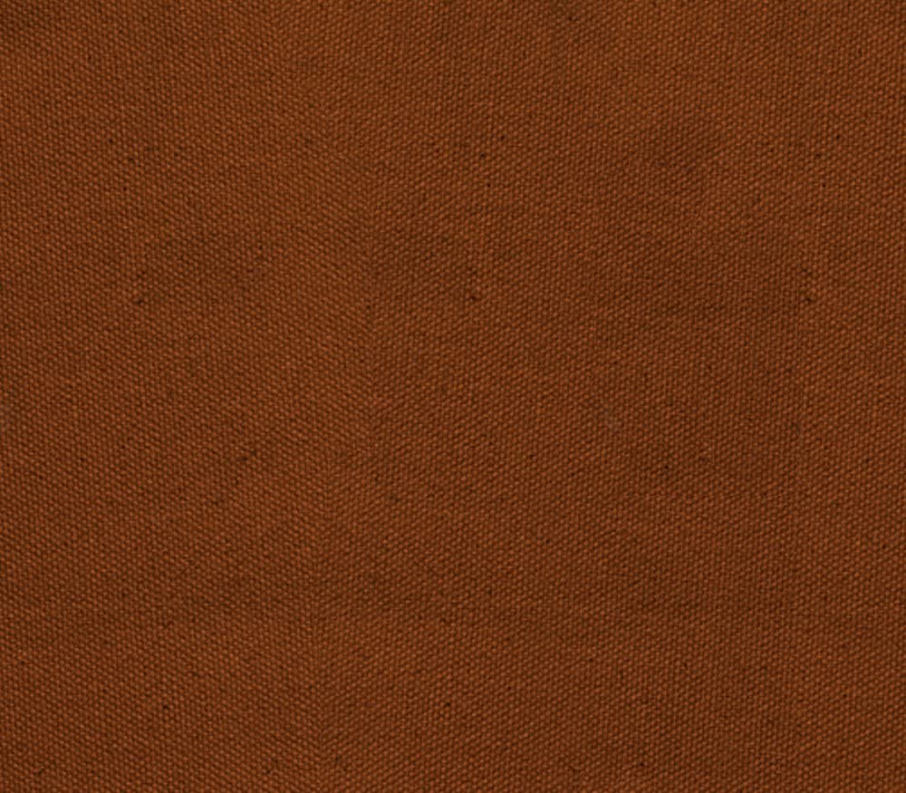 Close-up of heavy duty rust-colored denim fabric, for use in clothing or upholstery.