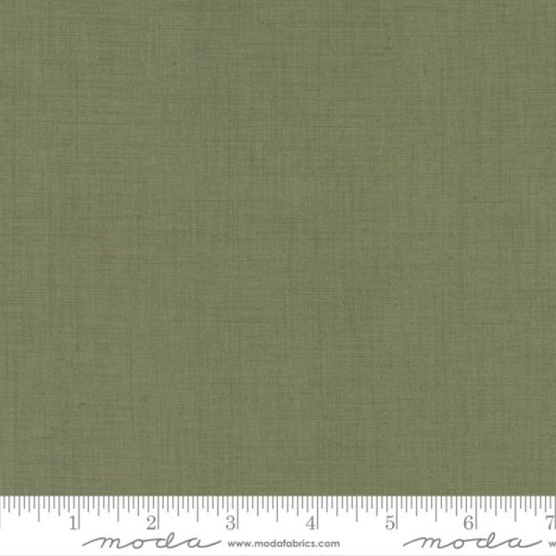 A solid green fabric swatch in cotton, marked with the brand Moda.