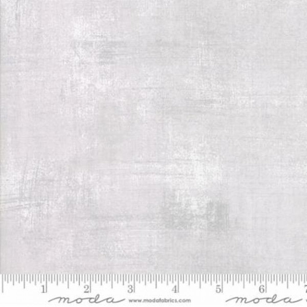 A swatch of grey textured quilting fabric with a ruler marked for scale.
