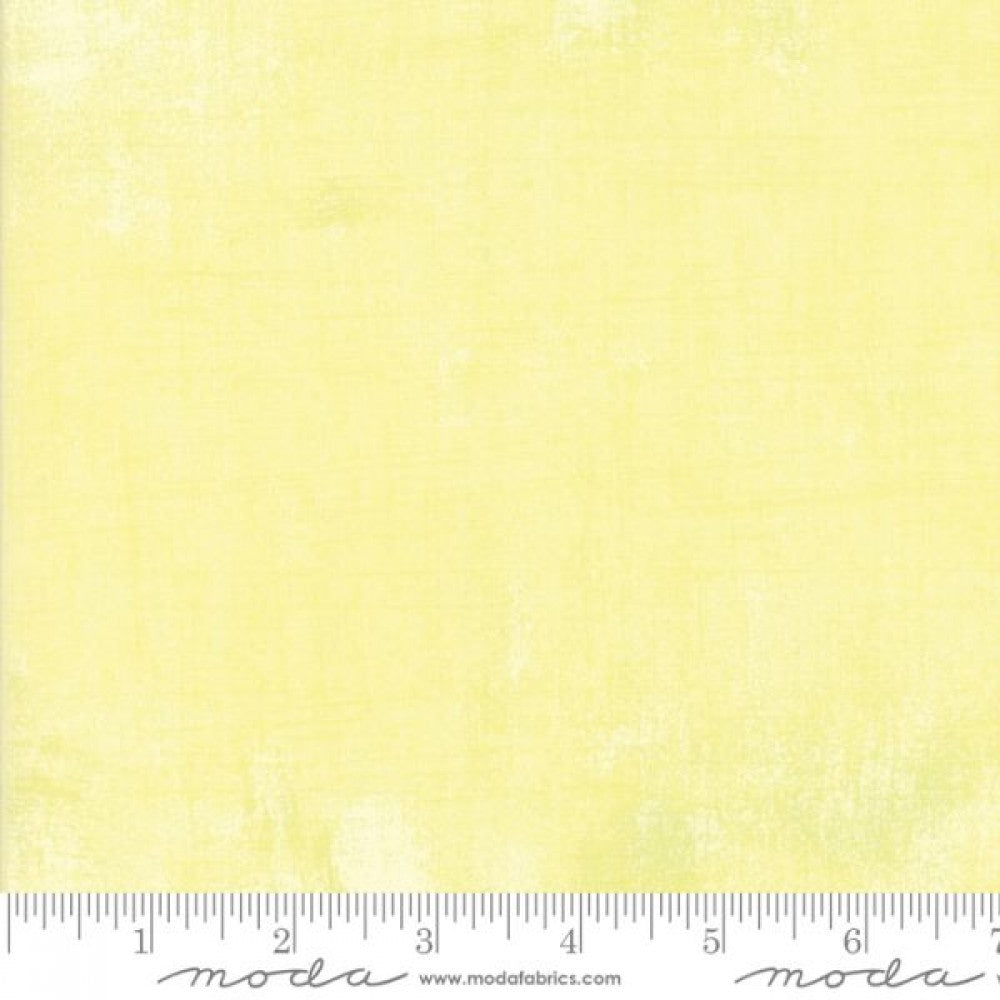A swatch of pale yellow blender quilting fabric with a textured effect.
