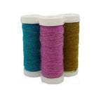 Three spools of sock reinforement yarn in teal, pink, and brown colors, arranged side by side.